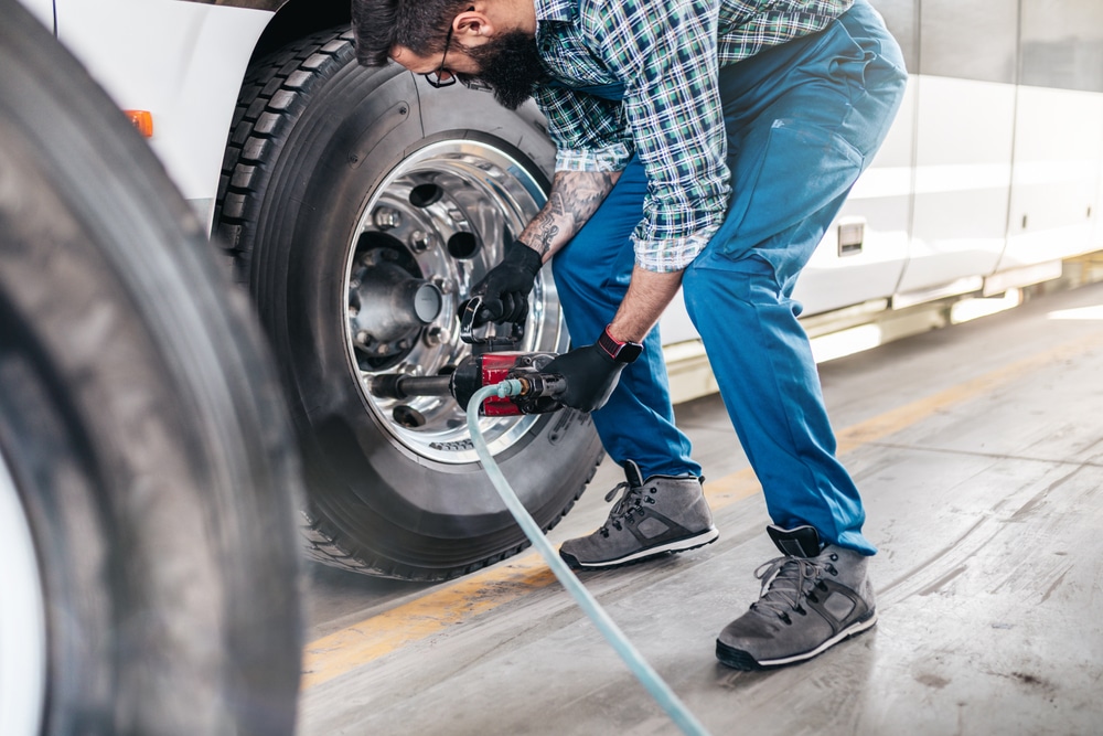 Mechanic worker changing tires on bus