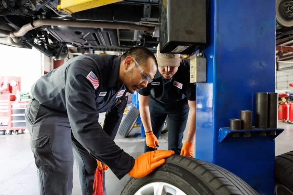 Harrell’s technician handling a wheel beneath a vehicle on a lift
